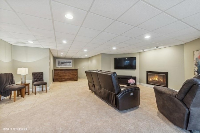 living room featuring a drop ceiling and light tile patterned floors