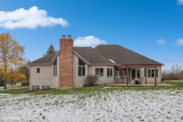 snow covered property with a patio area and a pergola