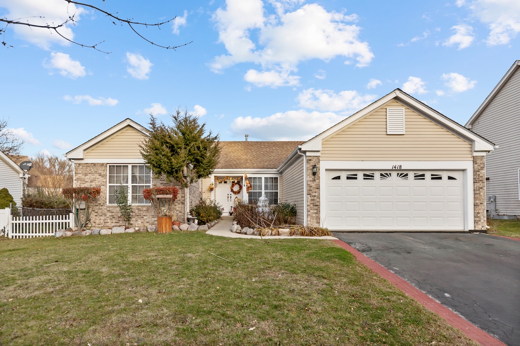 ranch-style house featuring a garage and a front lawn