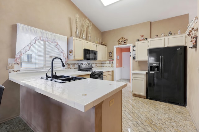 kitchen featuring kitchen peninsula, sink, vaulted ceiling, and black appliances