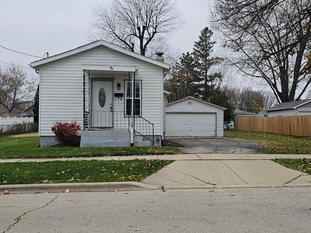 bungalow with a garage, an outdoor structure, and a front lawn