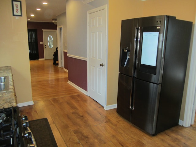 kitchen with wood-type flooring and stainless steel refrigerator with ice dispenser