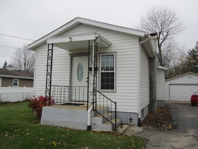 bungalow-style house with a garage and an outdoor structure