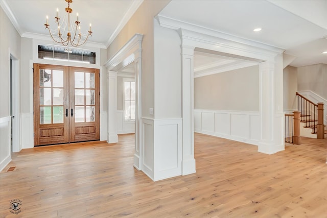 foyer with ornamental molding, french doors, a chandelier, and light hardwood / wood-style flooring