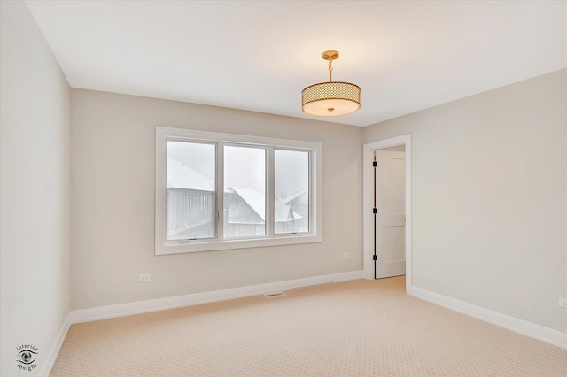 spare room featuring light colored carpet