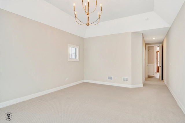 empty room featuring light colored carpet and a chandelier