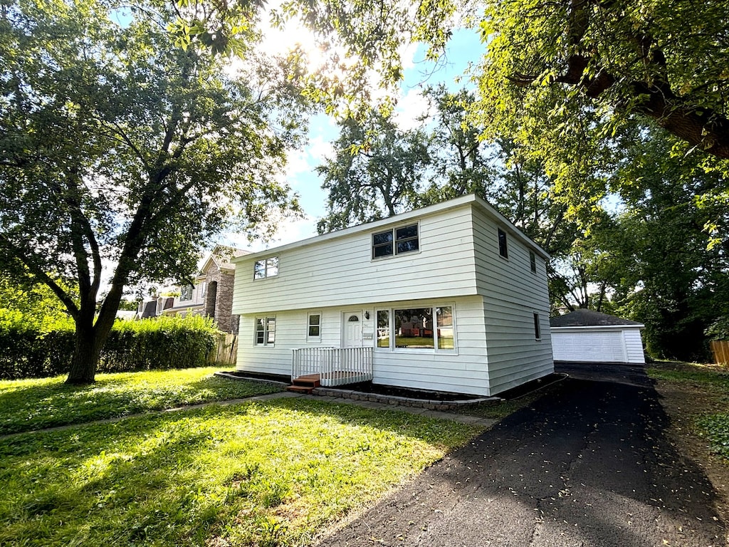 view of front of home with a front lawn, an outdoor structure, and a garage