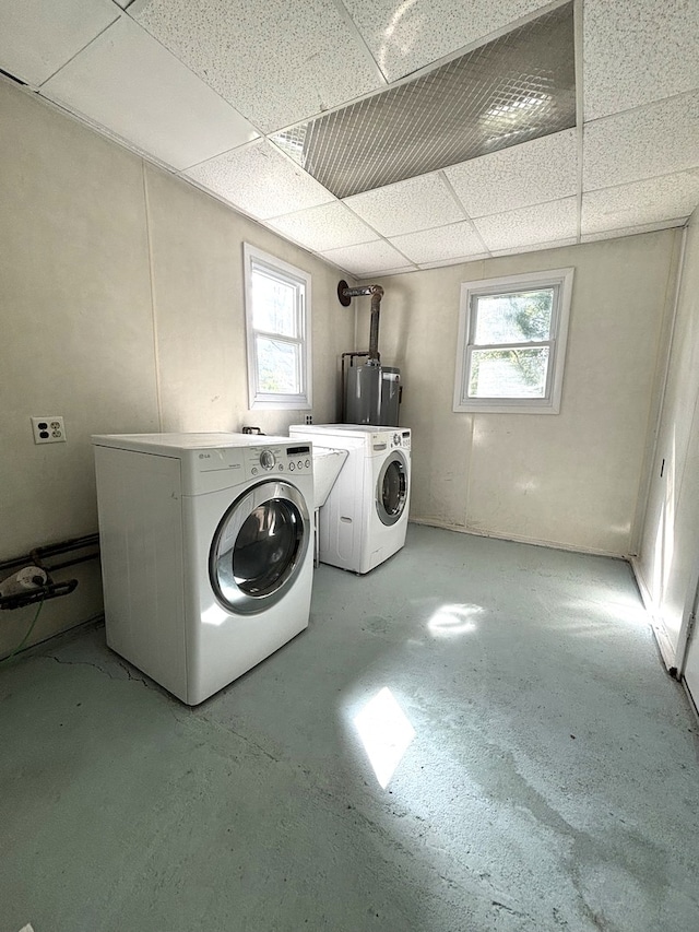 laundry room with washer and clothes dryer, a healthy amount of sunlight, and water heater