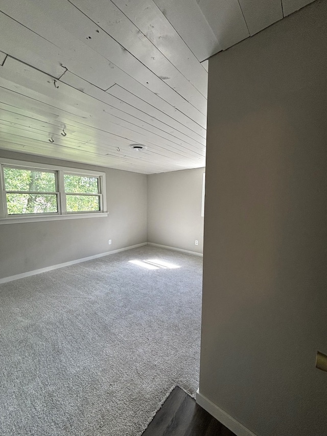 spare room with carpet flooring and wood ceiling