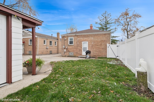 back of property with a yard and a patio