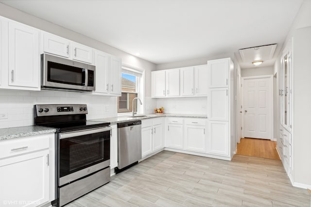 kitchen with white cabinetry, light hardwood / wood-style floors, and appliances with stainless steel finishes