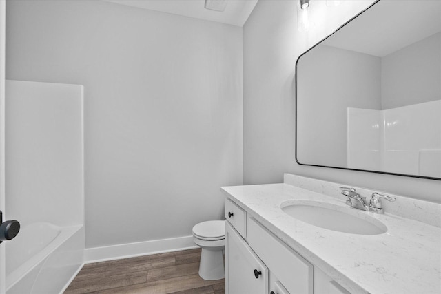 full bathroom with wood-type flooring, bathing tub / shower combination, vanity, and toilet