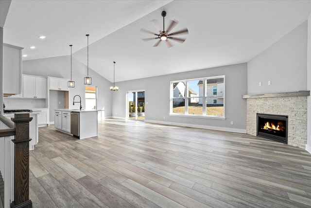 hallway with an inviting chandelier, light hardwood / wood-style flooring, and vaulted ceiling