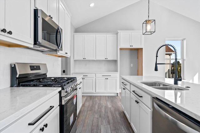 kitchen with sink, hanging light fixtures, white cabinets, and appliances with stainless steel finishes