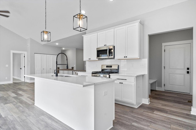 kitchen with a kitchen island with sink, sink, white cabinetry, and stainless steel appliances