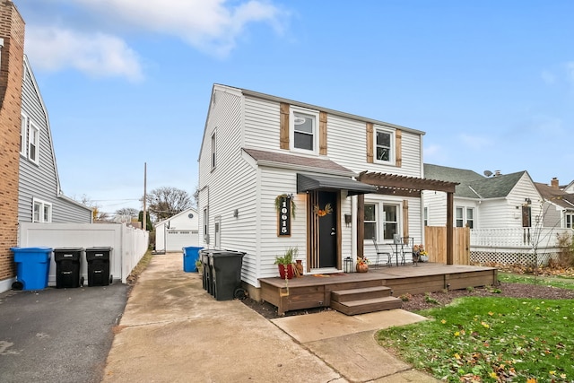 view of front property featuring a garage, an outdoor structure, and a wooden deck