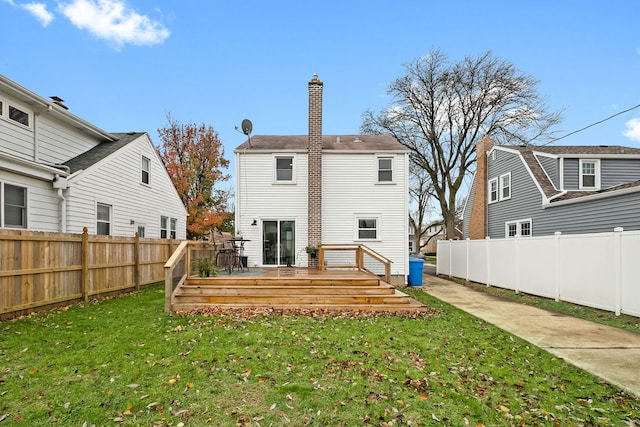 rear view of property with a wooden deck and a yard