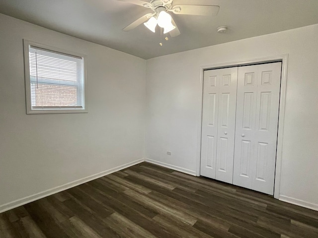 unfurnished bedroom with a closet, dark hardwood / wood-style floors, and ceiling fan