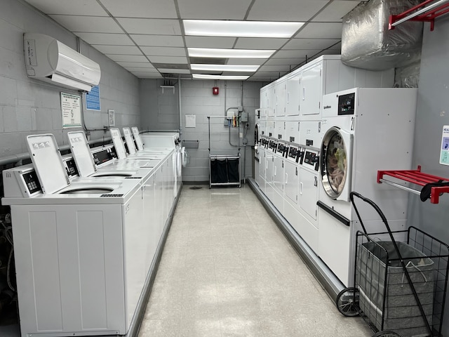 interior space with washer and clothes dryer, a wall mounted air conditioner, and stacked washer and clothes dryer