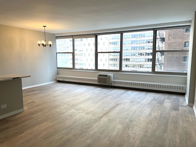 spare room featuring hardwood / wood-style floors and a chandelier