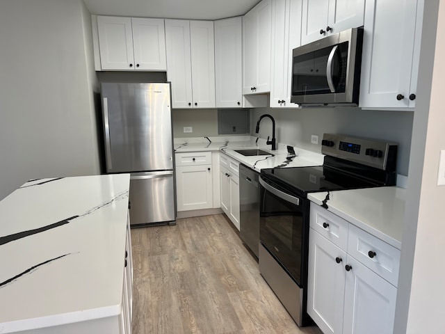 kitchen featuring light hardwood / wood-style flooring, stainless steel appliances, white cabinetry, and sink