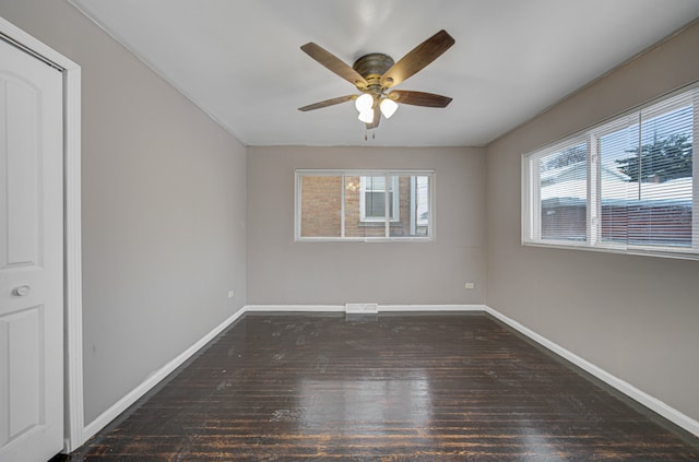 empty room with ceiling fan and dark wood-type flooring