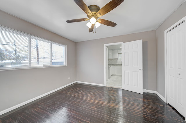 unfurnished bedroom featuring a closet, ceiling fan, and dark hardwood / wood-style flooring