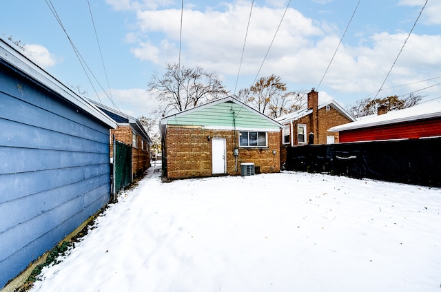 snow covered property with central AC unit