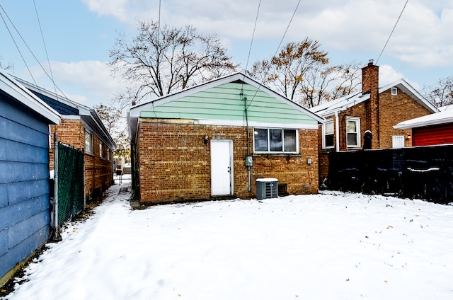 snow covered rear of property with central air condition unit