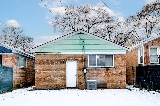 snow covered back of property featuring cooling unit