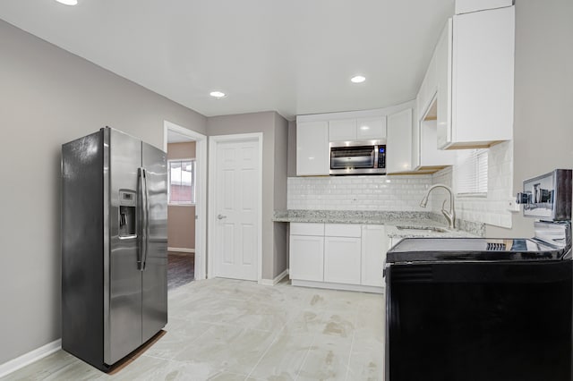 kitchen with sink, white cabinets, stainless steel appliances, and plenty of natural light