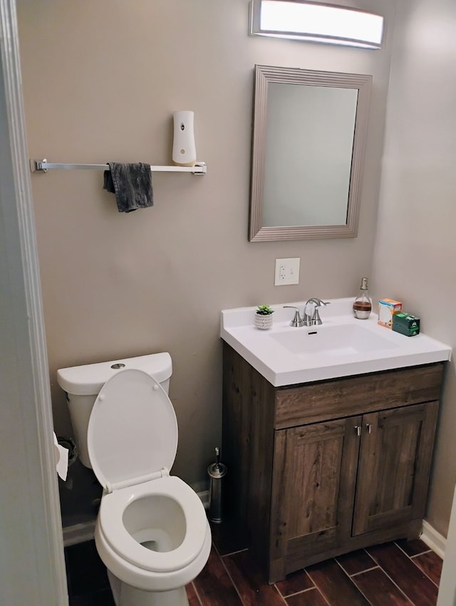 bathroom with vanity, wood-type flooring, and toilet