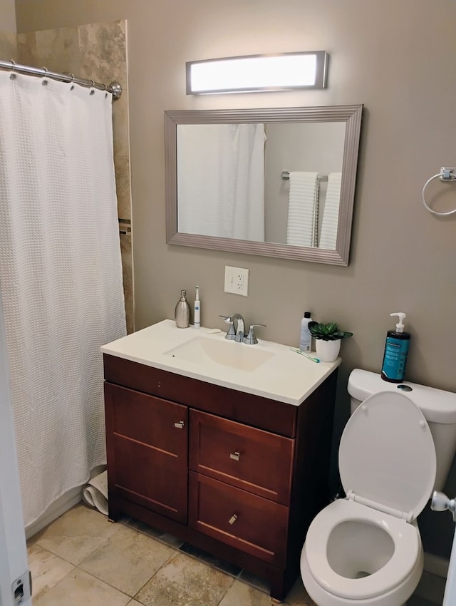 bathroom with tile patterned floors, vanity, curtained shower, and toilet