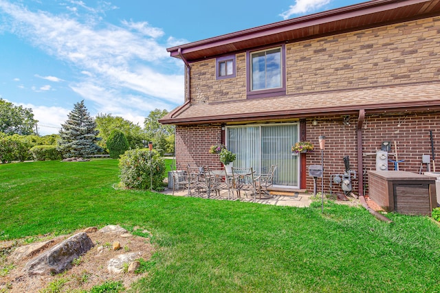 rear view of property featuring a patio and a lawn