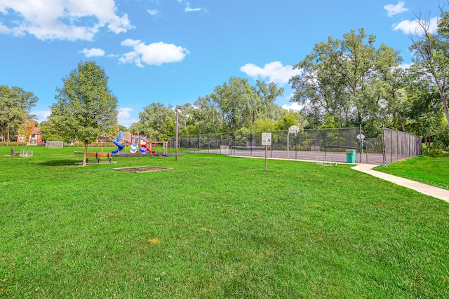 view of yard with a playground and basketball hoop