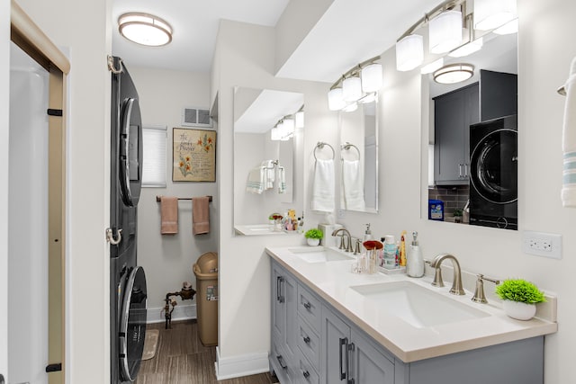 bathroom with stacked washer and dryer, vanity, and wood-type flooring