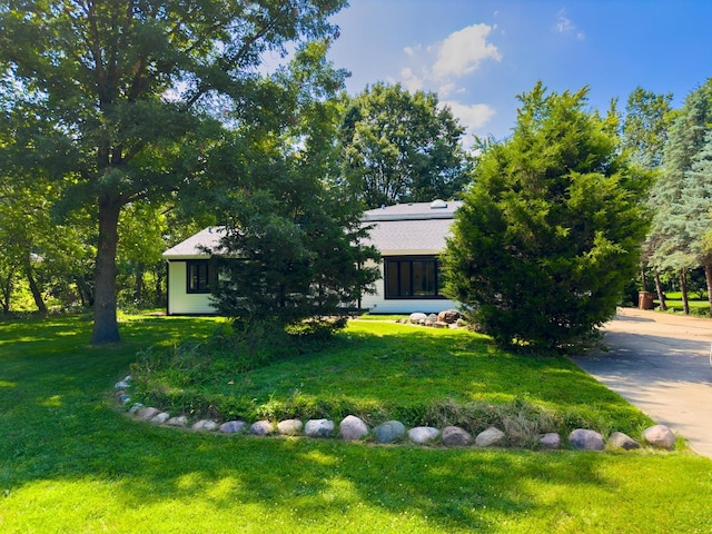 view of property hidden behind natural elements featuring a front lawn