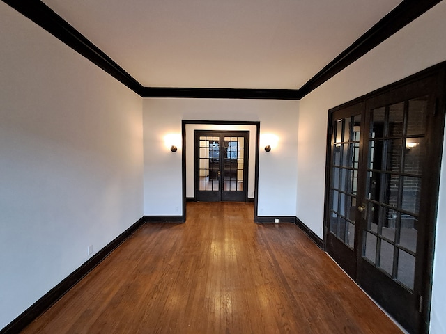 spare room featuring dark hardwood / wood-style floors, ornamental molding, and french doors