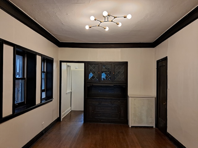 hallway featuring a chandelier, dark hardwood / wood-style floors, and ornamental molding