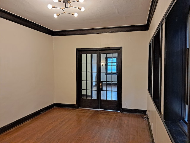 doorway featuring crown molding, french doors, dark hardwood / wood-style floors, and an inviting chandelier