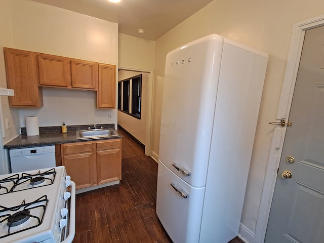 kitchen featuring white appliances, dark wood-type flooring, and sink