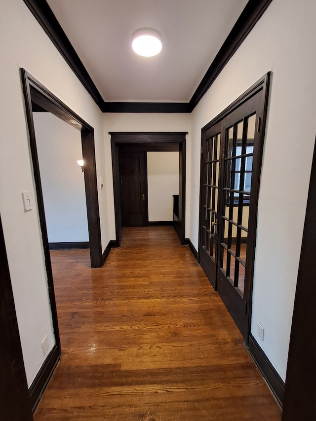 hall with crown molding, french doors, and dark wood-type flooring