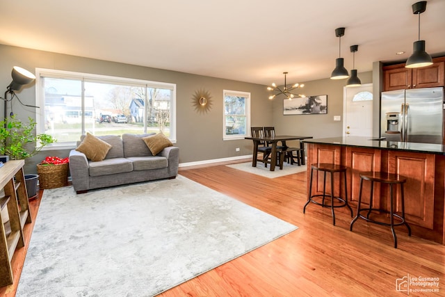 living room with light hardwood / wood-style floors and an inviting chandelier