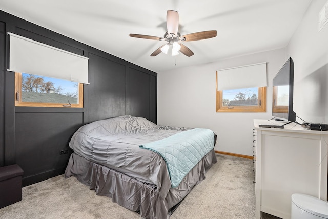 carpeted bedroom featuring multiple windows and ceiling fan