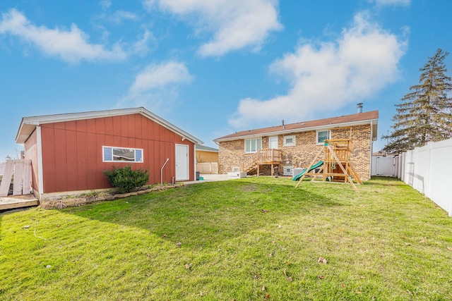 rear view of house with a playground and a yard