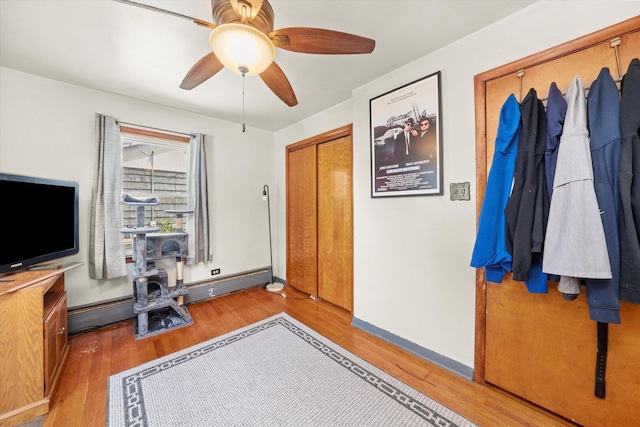 3820 W 117th St, Alsip, IL 60803 - bedroom with a wood stove, wood finished floors, a ceiling fan, and a baseboard radiator
