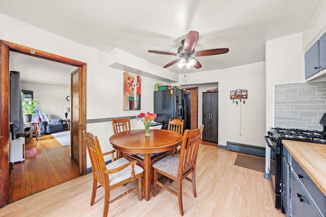 3820 W 117th St, Alsip, IL 60803 - dining space with light wood-type flooring, a ceiling fan, and a baseboard radiator