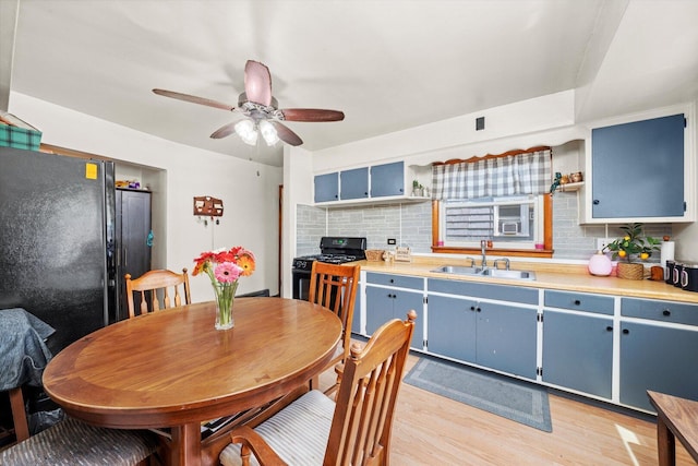 3820 W 117th St, Alsip, IL 60803 - kitchen featuring blue cabinets, black appliances, light wood-style flooring, decorative backsplash, and a ceiling fan