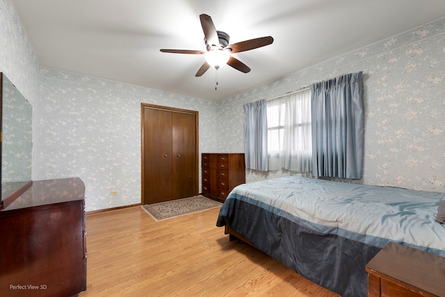 bedroom with ceiling fan, a closet, and light hardwood / wood-style flooring