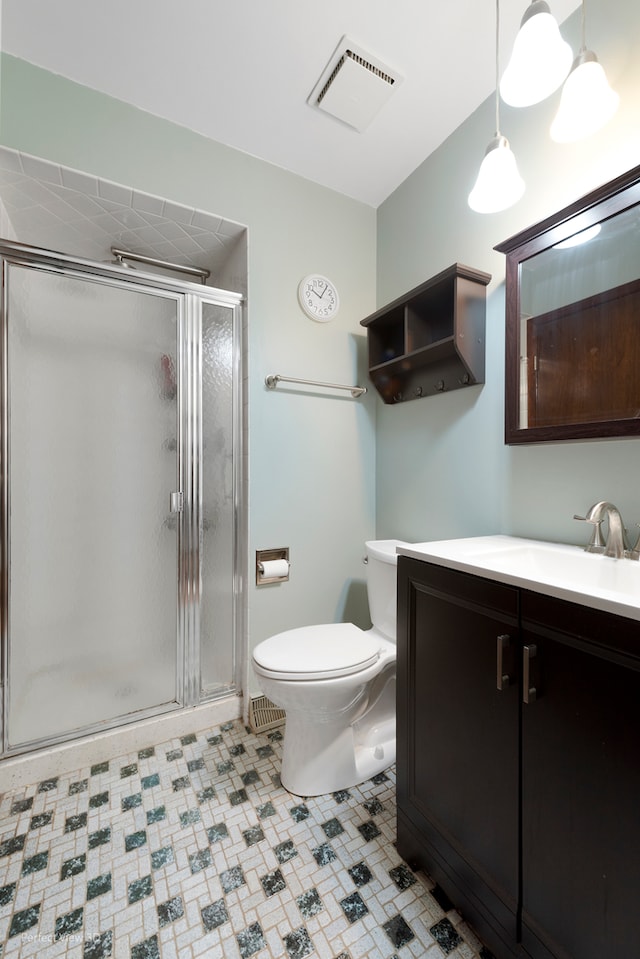 bathroom with tile patterned floors, a shower with door, vanity, and toilet